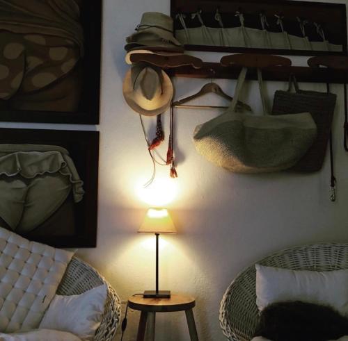 a room with a lamp and hats hanging on a wall at Comporta Cottage in Montevil