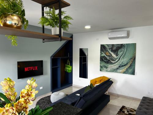 a living room with a couch and a painting on the wall at Mangata Loft - Requinte e Conforto para Lazer ou Trabalho in Itanhaém