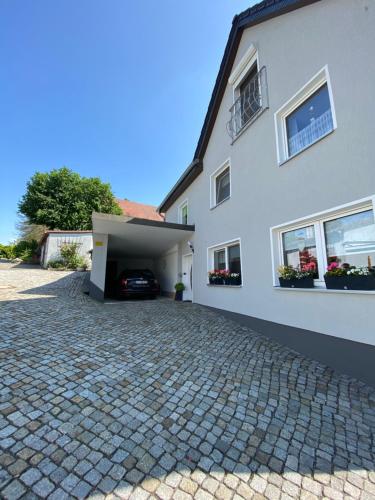 a white house with a garage and a driveway at Ferienhaus Zittau Oberlausitz & Ferienwohnung am Hamann Berg in Zittau