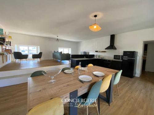 - une salle à manger et une cuisine avec une table et des chaises en bois dans l'établissement L'Escale Cherbourgeoise, à Cherbourg en Cotentin