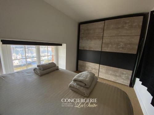 - une chambre avec un grand lit et une chaise dans l'établissement L'Escale Cherbourgeoise, à Cherbourg en Cotentin