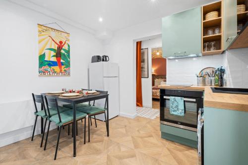 une cuisine avec une table et des chaises dans une pièce dans l'établissement Nice Renting - BARBERIS - Unique Getaway 2-Room with Rooftop Terrace, à Nice