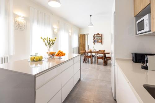 una cocina con armarios blancos y una mesa con frutas en Casantonia, en Recas