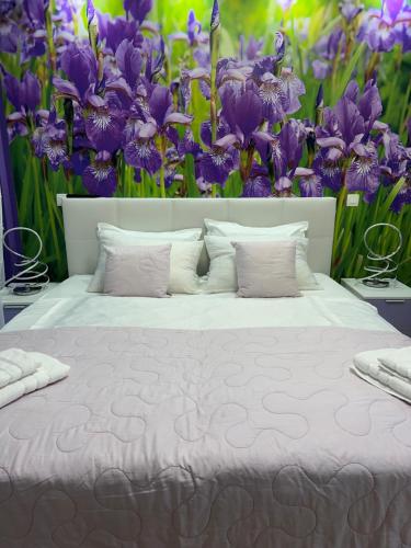 a bed with purple flowers in the background at Apartment Anaa in Radovljica