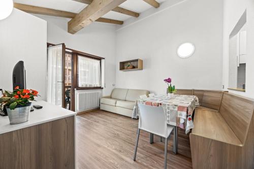 a kitchen and living room with a table and a couch at Aparthotel Des Alpes in Cavalese