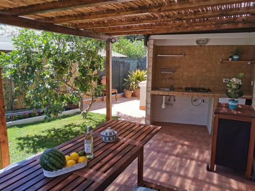 un tavolo in legno con un cesto di frutta su un patio di Argentario Cottage a Giannella