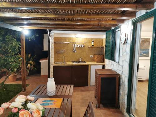 una cucina con tavolo e lavandino di Argentario Cottage a Giannella