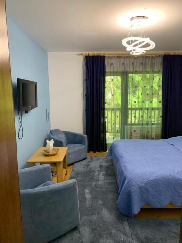 a bedroom with a bed and a couch and a tv at Pensiunea Mario in Moieciu de Sus