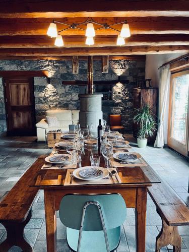 a wooden table with plates and wine glasses on it at La Vrille - Metcho in Verrayes