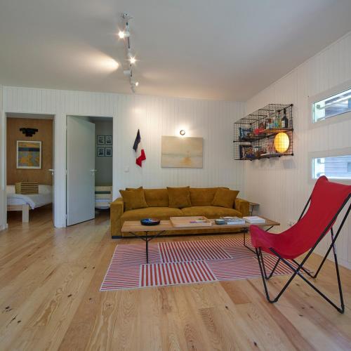 a living room with a couch and a red chair at Villa Marina de Talaris, Lacanau in Lacanau
