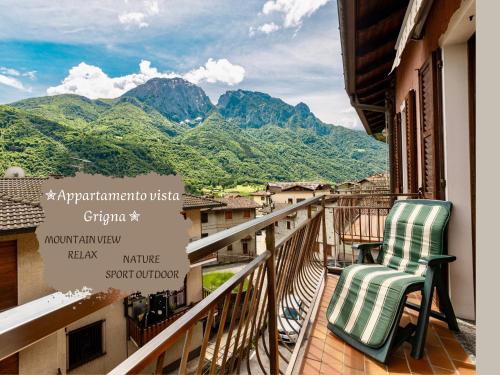 a balcony with two chairs and a view of mountains at Appartamento vista Grigna, Natura,sport e relax in Primaluna