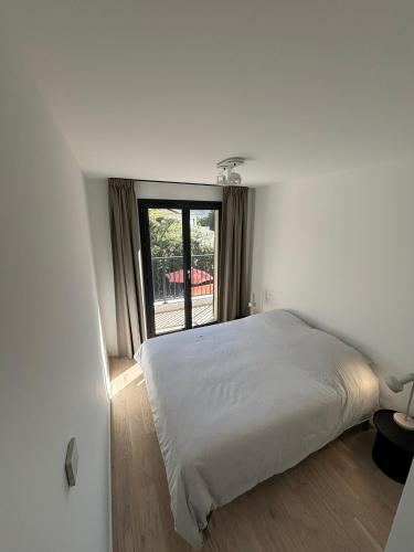 une chambre avec un lit blanc et une fenêtre dans l'établissement VillaGassin 403, à Saint-Tropez
