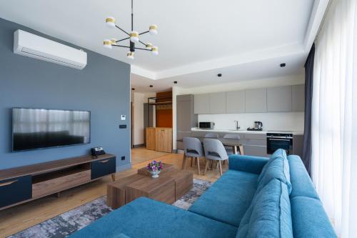 伊斯坦布尔The Superior Living Kağıthane的带蓝色沙发的客厅和厨房