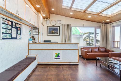 a lobby with a reception desk and a couch at Treebo Maharaja, Near Mall Road in Shimla