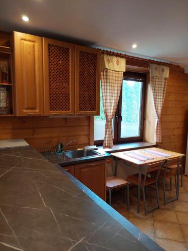 a kitchen with a sink and a table with chairs at vila Happy in Veľká Lomnica