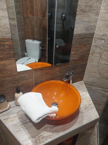 an orange sink in a bathroom with a toilet at vila Happy in Veľká Lomnica