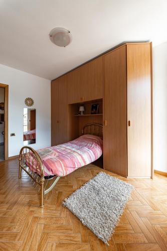 a bedroom with a bed and a wooden cabinet at Appartamento vista Grigna, Natura,sport e relax in Primaluna