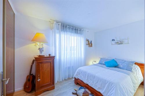 une chambre avec un lit avec une lampe et une guitare dans l'établissement Grand appartement avec jacuzzi et terrasse de 55m2, à Bayonne
