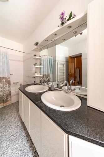 a bathroom with two sinks and a large mirror at Appartamento vista Grigna, Natura,sport e relax in Primaluna