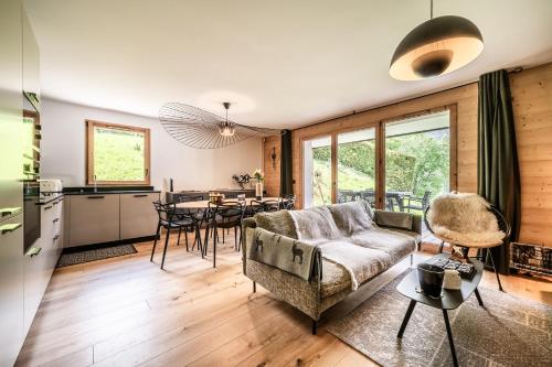 un salon avec un canapé et une table dans l'établissement Apartment Lupin Megève - by EMERALD STAY, à Megève