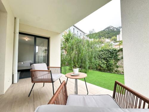 d'une terrasse avec une table et des chaises ainsi que d'un jardin. dans l'établissement Krystal Garden, Bnbrickeys., à Beausoleil