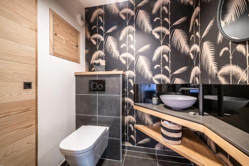 La salle de bains est pourvue d'un papier peint noir et blanc. dans l'établissement Apartment Lupin Megève - by EMERALD STAY, à Megève