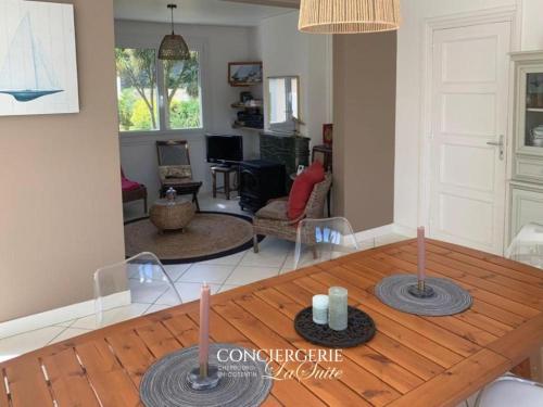 - un salon avec une table en bois et une salle à manger dans l'établissement Frangipanie, à Urville-Nacqueville