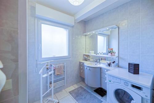 une salle de bain avec un lavabo et une machine à laver dans l'établissement Grand appartement avec jacuzzi et terrasse de 55m2, à Bayonne