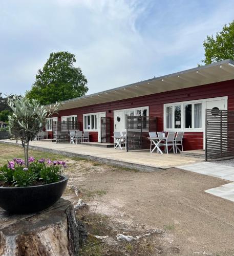 un edificio rojo y blanco con mesas y sillas en Hälleviks Havsbad, en Hällevik
