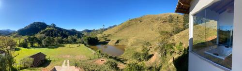 an aerial view of a mountain with a lake at Chalé vista do lago in Resende
