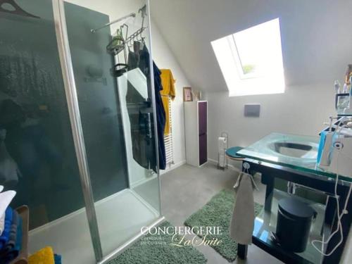 une salle de bain avec une douche en verre et un lavabo dans l'établissement La Feroni, à Valcanville