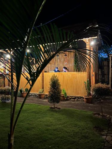 a person sitting on a fence in a yard at night at Kurni's Cabin in Sapit