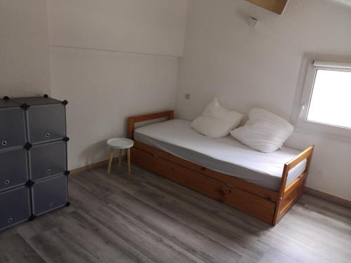 une petite chambre avec un lit et une fenêtre dans l'établissement Vacances à Vic avec piscine collective, à Vic-la-Gardiole