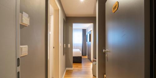 a hallway with a door leading to a bedroom at PLAZA INN Rieker Stuttgart Hauptbahnhof in Stuttgart