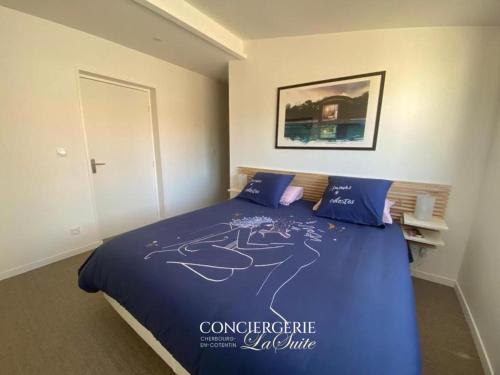 une chambre avec un lit avec une couette bleue dans l'établissement La fauvette, à Barneville-Carteret