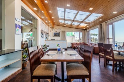 a dining room with a table and chairs at Treebo Maharaja, Near Mall Road in Shimla