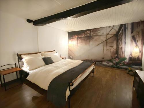 Un dormitorio con una cama grande con un cuadro en la pared. en Haus Auenland, en Groß Felda