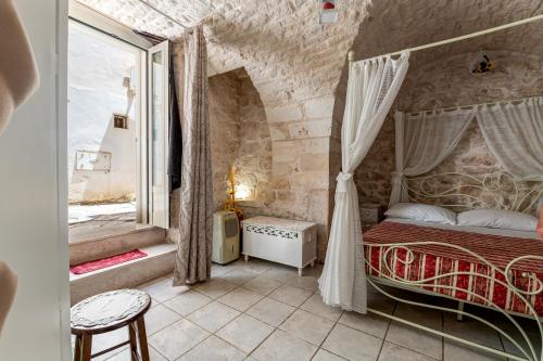 Un dormitorio con una cama en una pared de piedra. en Profumo di Pietra, en Martina Franca