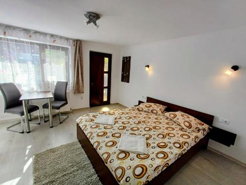 a bedroom with a bed and a table and chairs at Casa Șallai in Sovata