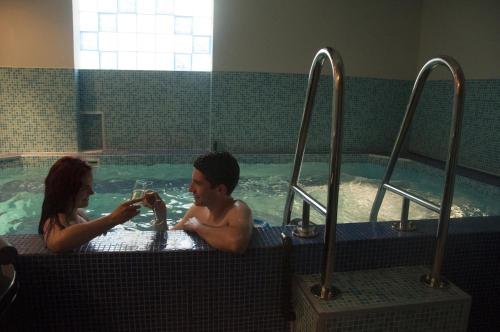 a man and a woman in a swimming pool at Hotel Kralj in Vrnjačka Banja