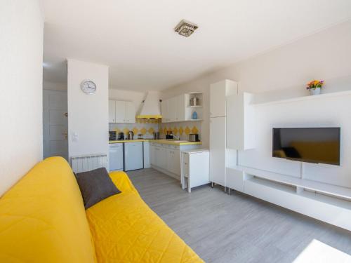 un salon avec un canapé jaune et une cuisine dans l'établissement Apartment La Croix du Sud-29 by Interhome, à Cavalaire-sur-Mer