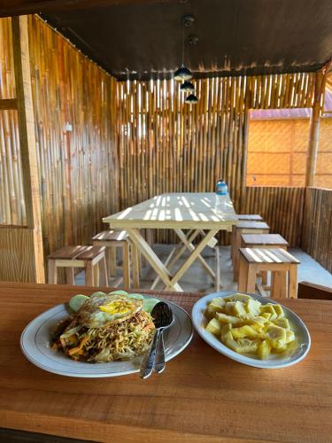 a table with two plates of food and chips at Kurni's Cabin in Sapit