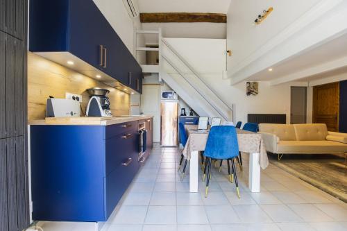 a kitchen with blue cabinets and a table with blue chairs at Gite Grand Luberon chez Manon en Luberon - Vacation rental in guest house in Lagnes