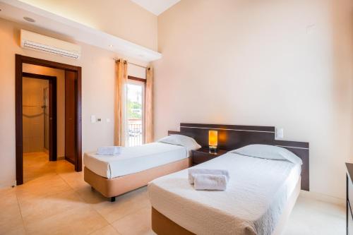 a bedroom with two beds and a window at Capetown Marina Luxury Villa - Private Pool in Albufeira
