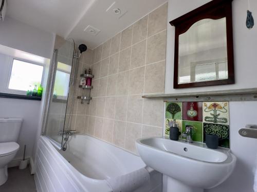 ein Badezimmer mit Waschbecken, Badewanne und Toilette in der Unterkunft Seacroft - 3 Bed Georgian Listed Townhouse with Wood Burning Stove in Ilfracombe
