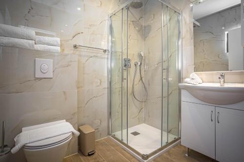 a bathroom with a shower and a toilet and a sink at Apartments Ivan in Baška Voda