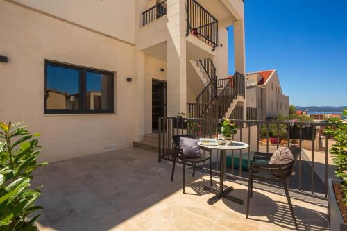 a balcony of a house with a table and chairs at Apartments Ivan in Baška Voda