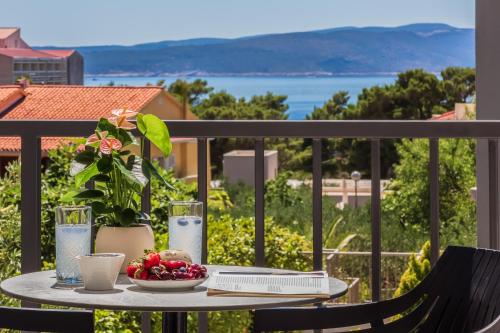 a table with a bowl of fruit on a balcony at Apartments Ivan in Baška Voda