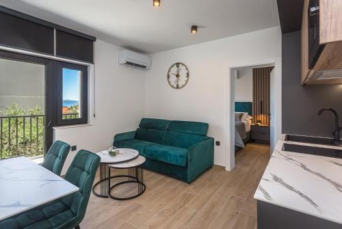 a living room with a green couch and a table at Apartments Ivan in Baška Voda