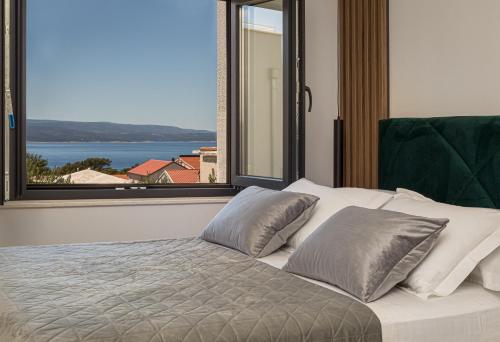 a bedroom with a bed with a large window at Apartments Ivan in Baška Voda
